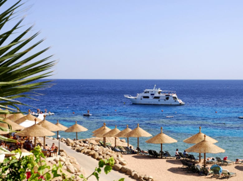 Red Sea beach in Egypt with cruise and tourists enjoying the sea view 