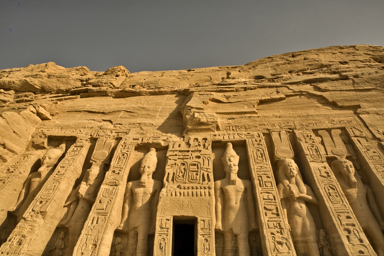Ancient stone carvings with hieroglyphics grace an Egyptian temple facade—live the magic!.