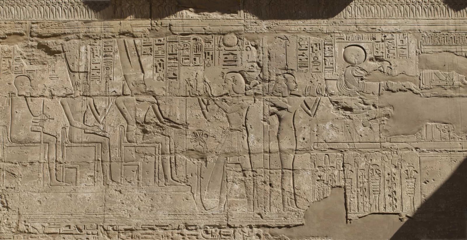 Luxors ancient Egyptian hieroglyphic stone carving with figures and symbolic elements.