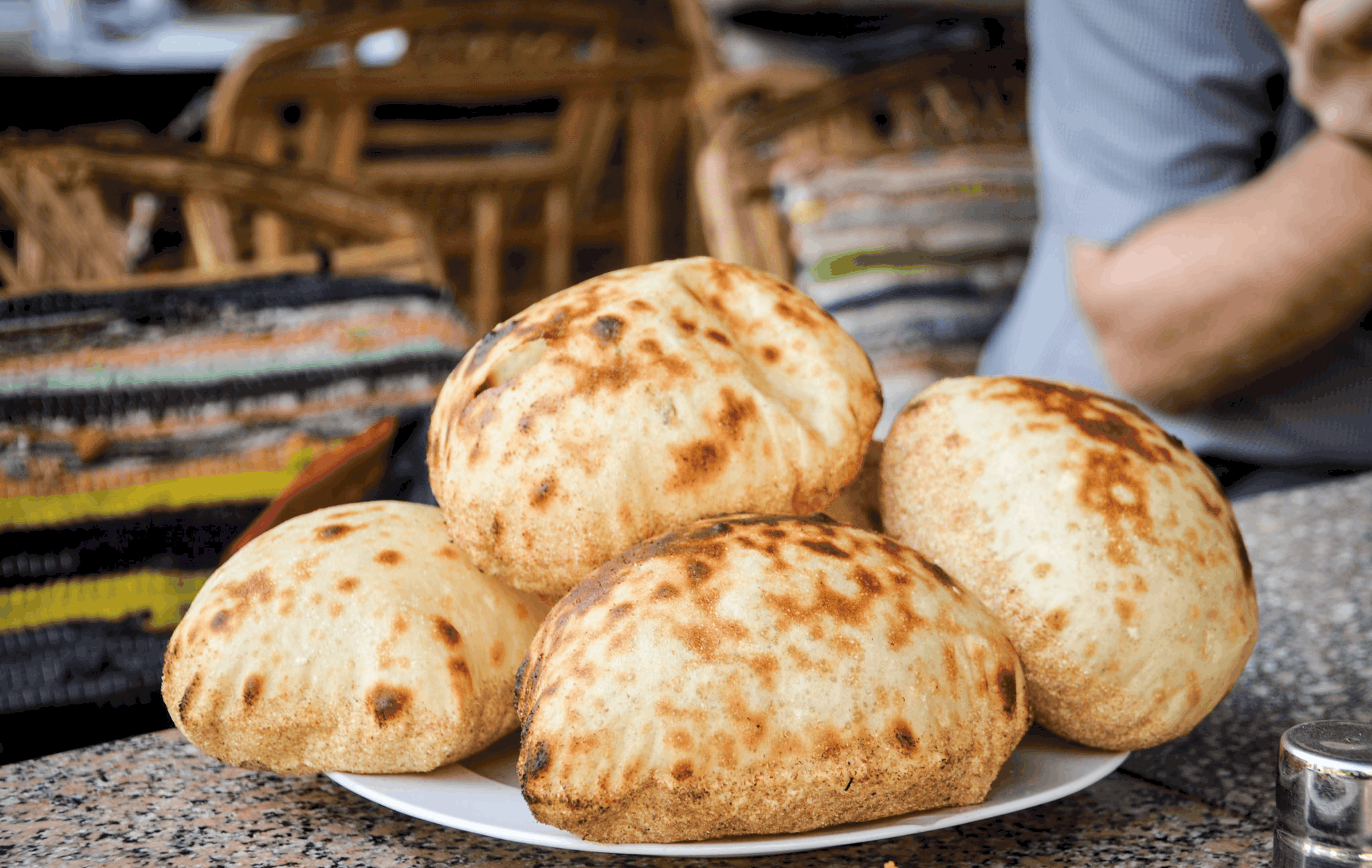 A plate of freshly baked round bread loaves, reminiscent of traditional Egyptian dishes.