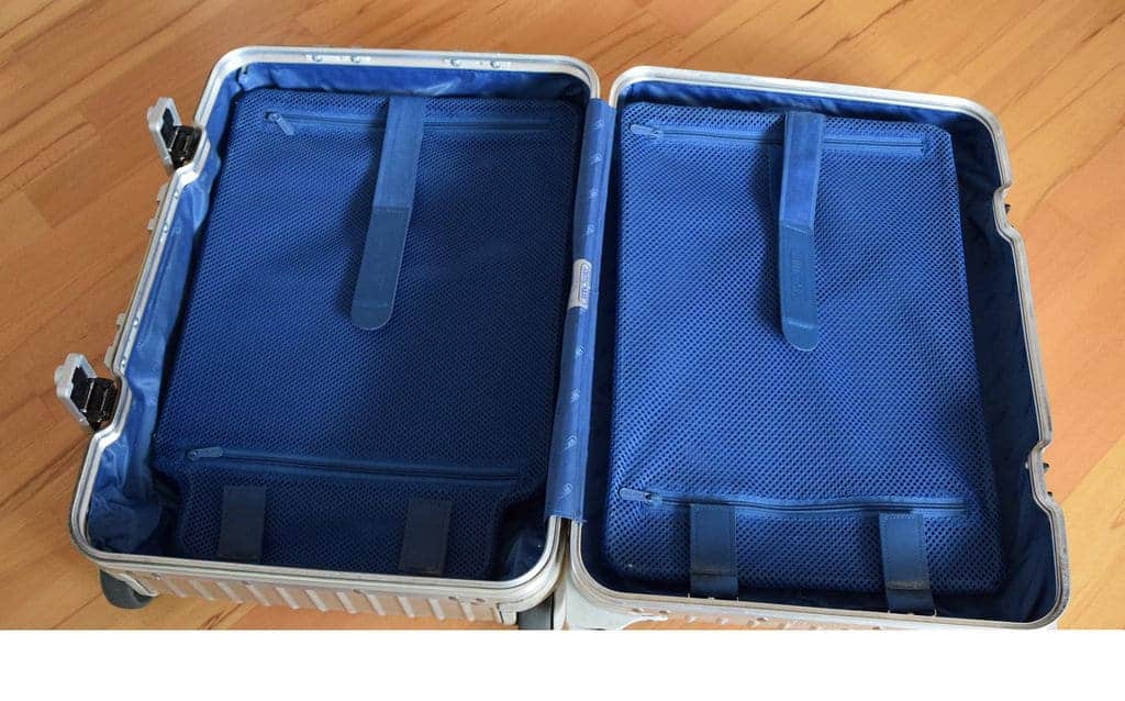 Open silver suitcase with blue interior on a wooden floor, ready for your Nile cruise essentials.