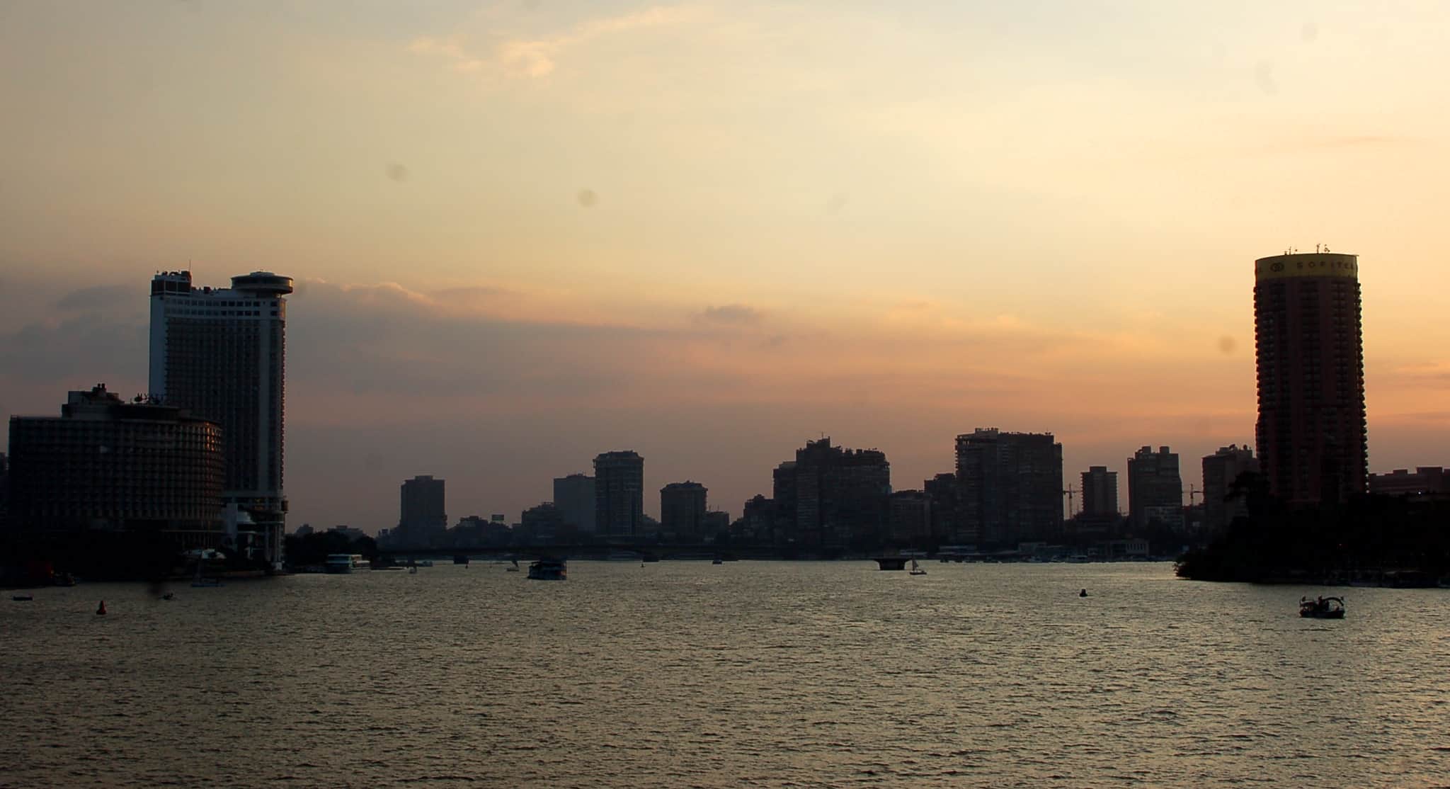 Cairo skyline at sunset silhouettes over the river, a guide to top restaurants nearby.