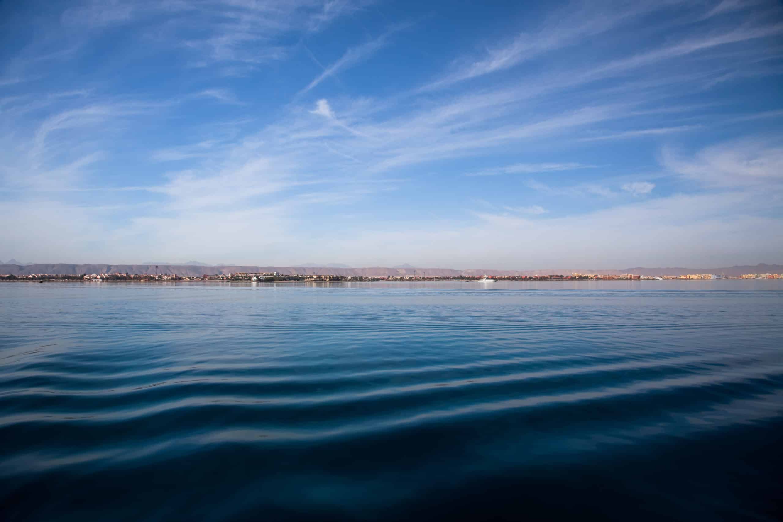 Serene blue ocean ripples under El Gounas clear sky.