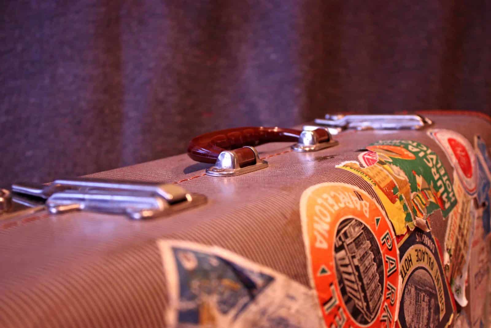 Close-up of a vintage suitcase covered with travel stickers from the Nile.