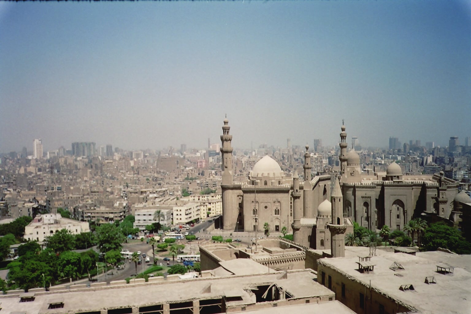 Cairos skyline with historic mosques and cityscape under a clear blue sky.