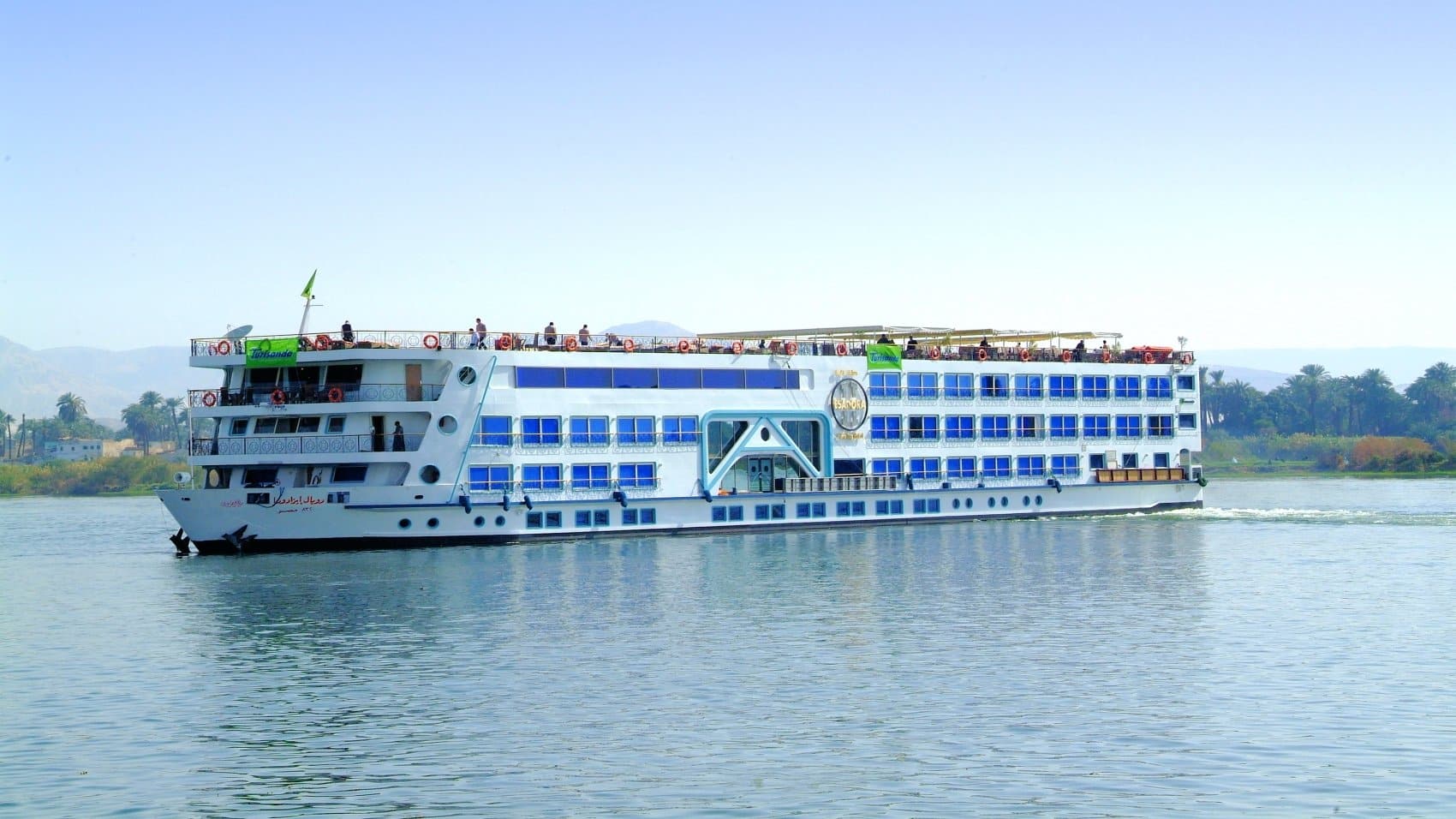 Luxor cruise ship glides under clear skies on calm Nile waters.