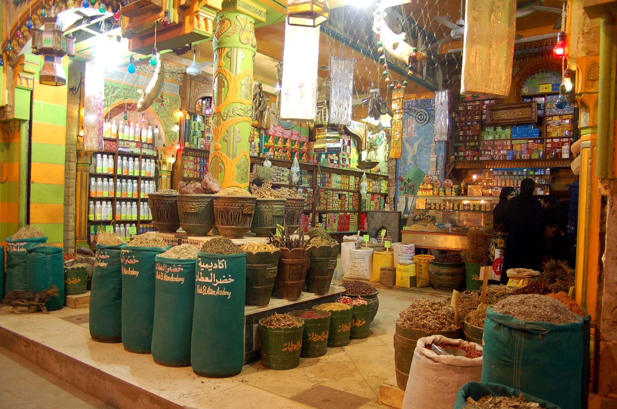 Spice shop with colorful sacks and jars in a vibrant, historic Cairo market setting.