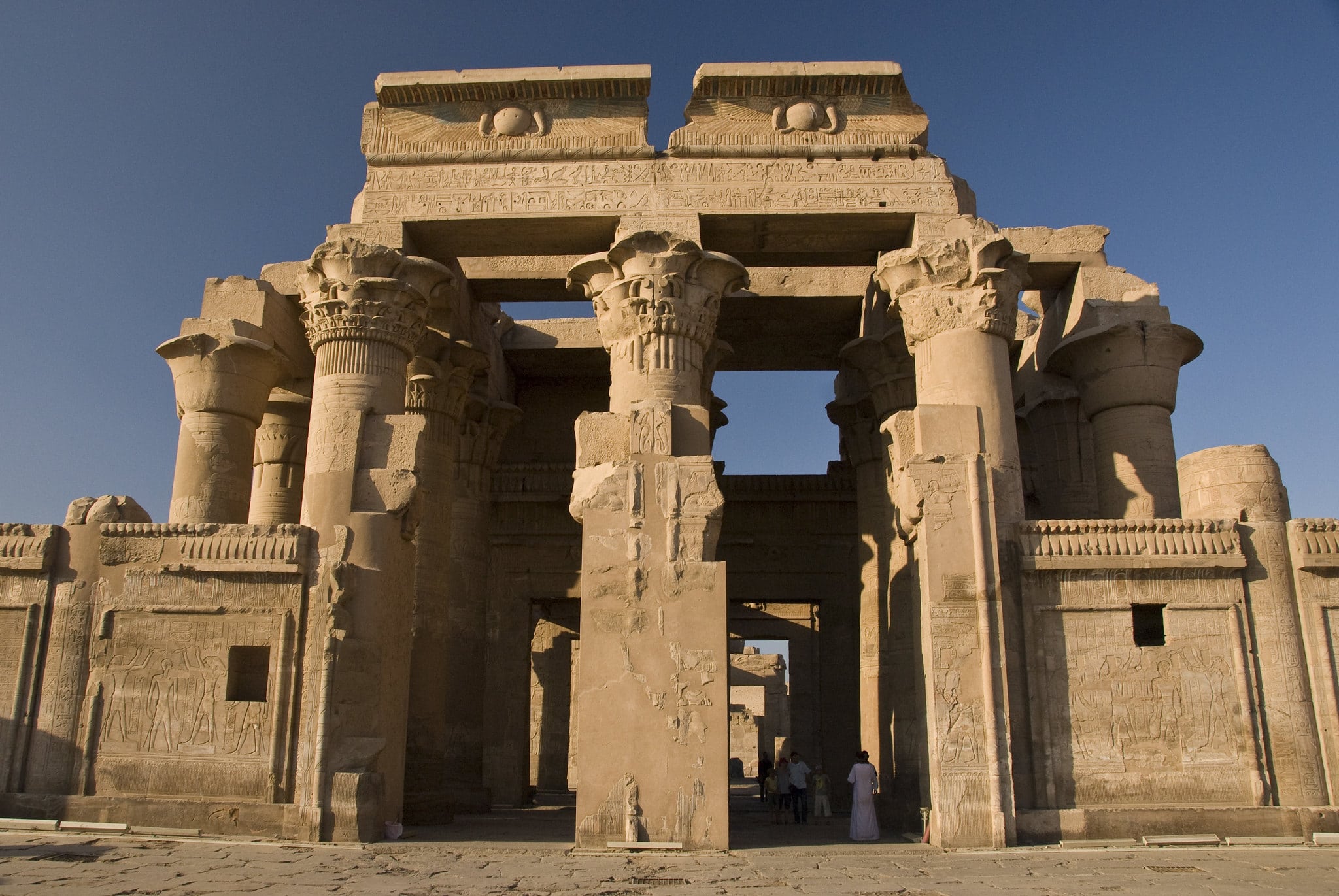 Ancient Egypt stone temple with columns under a clear blue sky.