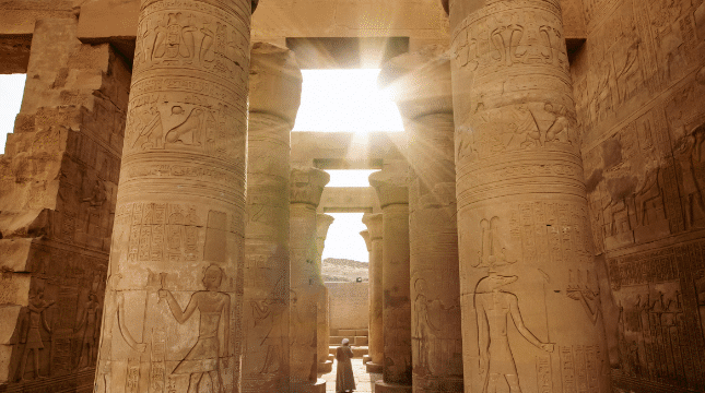 Nile River boats sail by ancient columns; sunlight and hills reveal Egypts timeless allure.
