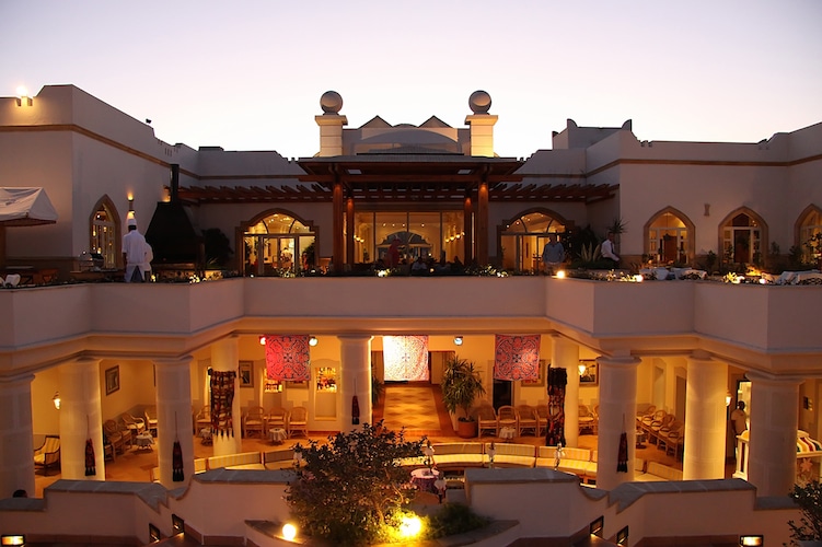 Royal Grand Sharm hotel glows at dusk with elegant arches and balconies.