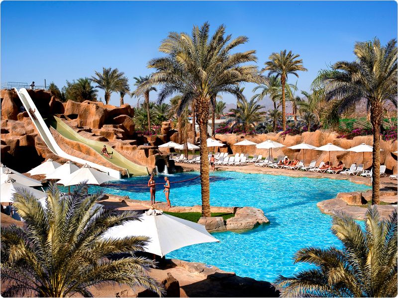 Sentido Reef Oasis Senses Resort: A pool, waterslides, and palm-lined lounge chairs await you.