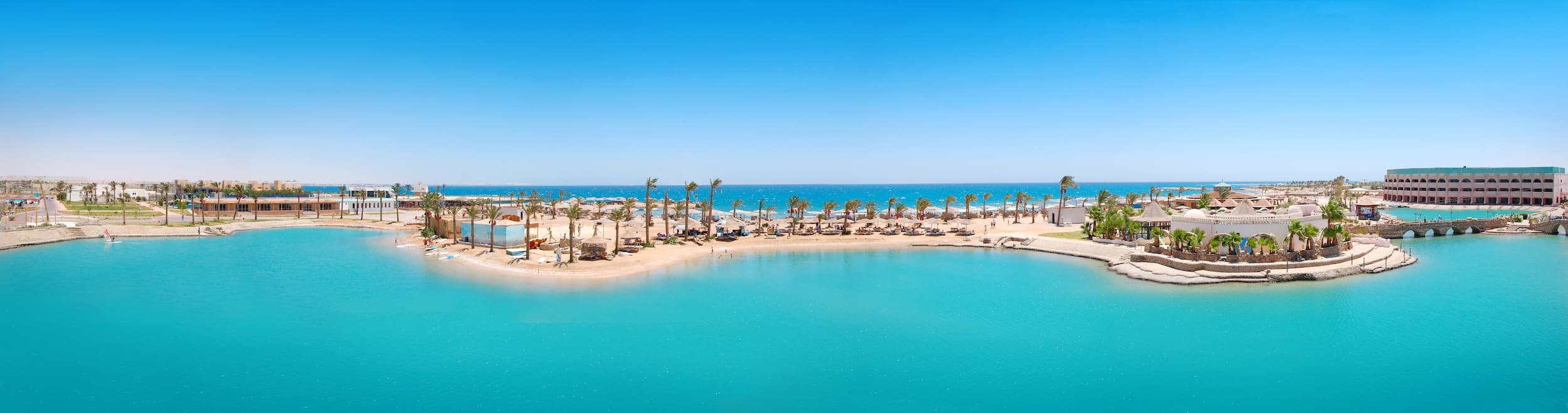 Coastal resort with palm trees, blue lagoons, and sandy beach near Hurghada Hotels.