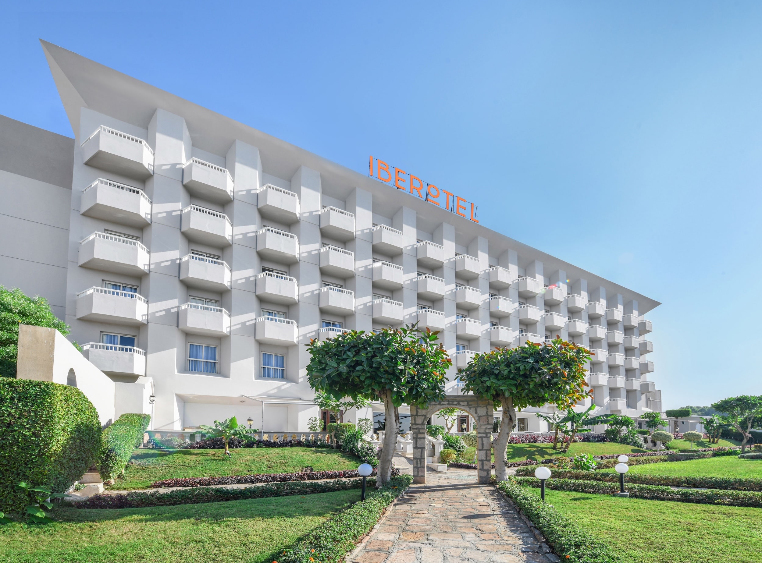 Iberotel Luxor Hotel showcases a modern design with balconies overlooking a manicured garden.