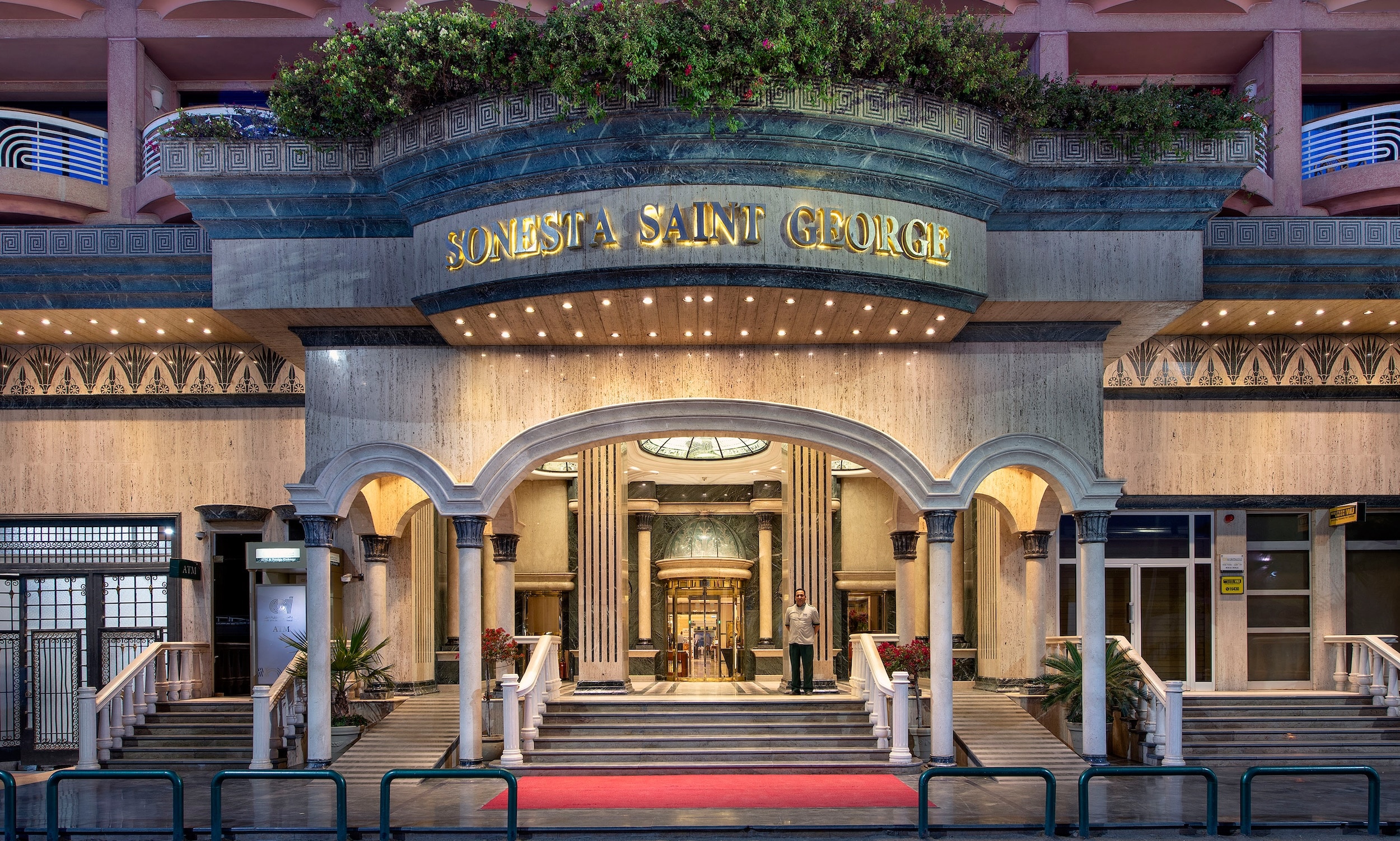 Sonesta St George Luxor entrance flaunts arches, a red carpet, and its iconic sign.