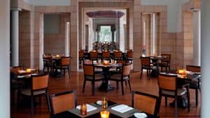 Elegant restaurant at Marriott Mena House with tables, chairs, and warm lighting.