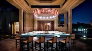 Luxurious Marriott Mena House bar with a large chandelier and surrounding cushioned chairs.