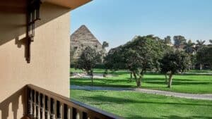 View from the Marriott Mena House balcony, overlooking trees with a pyramid in the background.