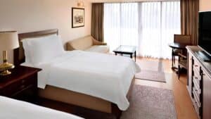 Marriott Mena House room: bed, sofa, desk, and a large window with curtains.