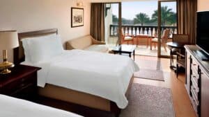Marriott Mena House room: two beds, sofa, balcony, and palm tree views.