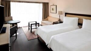 Marriott Mena House room: two beds, sofa, desk, and a large window with curtains.