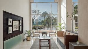 Bright room at Marriott Mena House, with large windows, seating area, plants, and artworks.