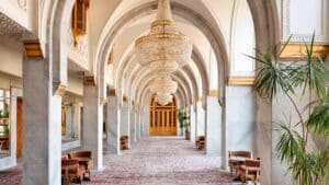 Elegant hallway at Marriott Mena House with arched ceilings, chandeliers, and decorative carpet.
