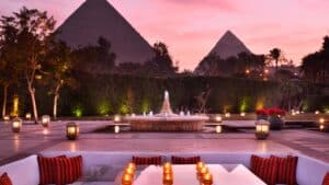 Outdoor seating at Marriott Mena House with lit candles facing pyramids at sunset.
