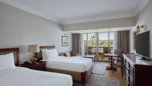 Marriott Mena House room: two beds, TV, window with a tree view.