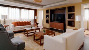 Modern living room with sofas, chairs, a Sheraton Cairo vibe, large TV, and tall windows.