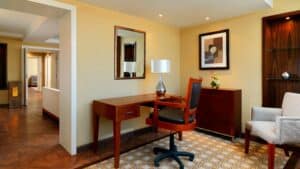 Modern room at Sheraton Cairo with desk, chair, lamp, and artwork on walls.