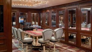 A poker table with chairs in the Sheraton Cairos wood-paneled casino room.