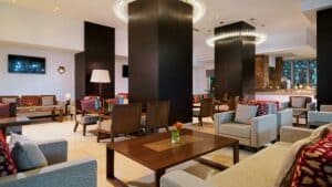 Modern lobby at Sheraton Cairo with stylish seating, tables, and grand chandeliers.