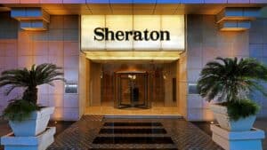 Hotel entrance with Sheraton Cairo Hotel & Casino sign and two potted plants.