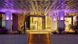 Entrance of the Sheraton Cairo Hotel with an illuminated purple ceiling and stairs.