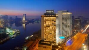 Sheraton Cairo Hotel & Casino lights up the cityscape with vibrant reflections over the river.