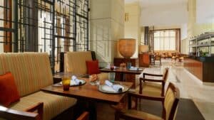 A modern dining area at Sheraton Cairo with striped chairs in a bright, spacious room.
