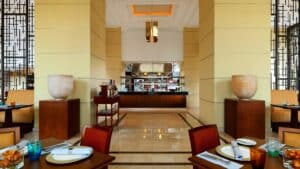 Elegant Sheraton Cairo dining area with tables, chairs, and a buffet zone.