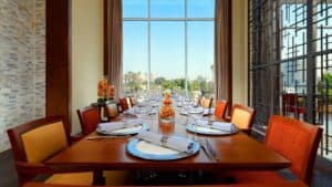 Elegant dining set for twelve at a modern restaurant in Sheraton Cairo Hotel with city views.