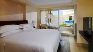 Sheraton Cairo room with bed, TV, and patio access to pool loungers.