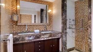 Luxurious bathroom at Sheraton Cairo Hotel with double sinks and tiled shower.