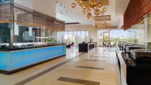 Spacious modern buffet at Sheraton Cairo Hotel with serving stations and pendant lights.