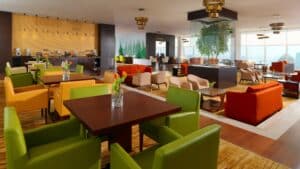 Modern lounge at Sheraton Cairo with colorful seating, dining tables, and a buffet backdrop.