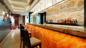 A modern bar in Sheraton Cairo with a glowing marble counter and high chairs.
