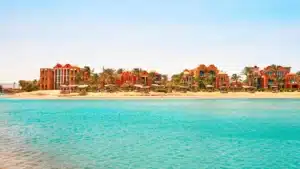 Sheraton Miramar Resort: Beachfront with vibrant buildings by a turquoise sea under clear skies.