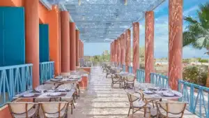 Sheraton Miramar Resorts outdoor patio features tables, chairs, and pillars under a decorative canopy.