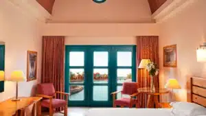 Sheraton Miramar Resort room: large windows, two chairs, table, view of water and buildings.
