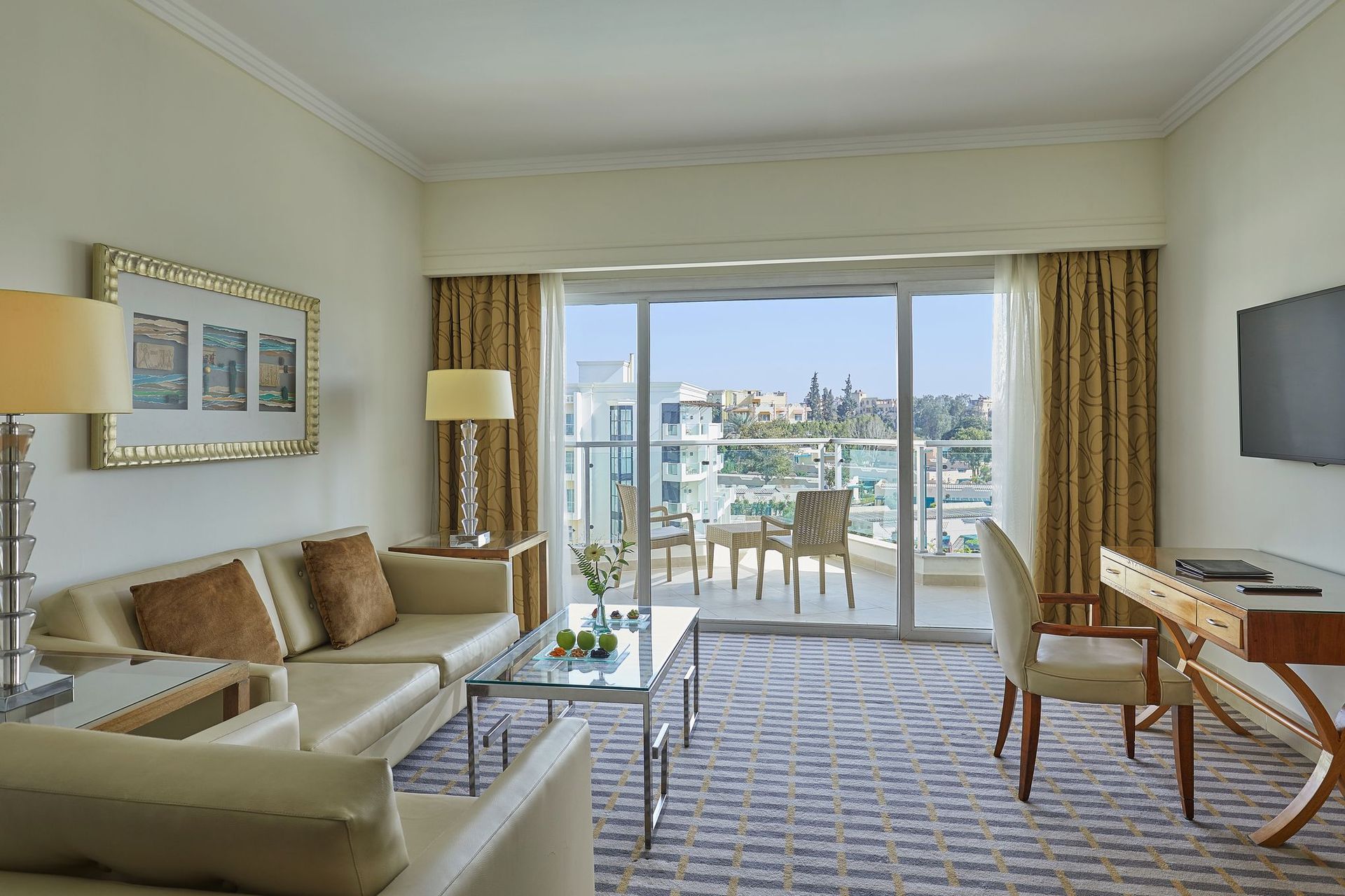 Steigenberger Pyramids room with seating, desk, and stunning balcony view.