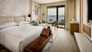 Sheraton Cairo Hotel room: modern, with a bed, sofa, desk, and balcony chairs.