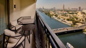 View from a balcony at Sheraton Cairo Hotel & Casino, overlooking a river and distant towers.