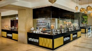 A Sheraton Cairo Hotel buffet with assorted dishes, plates, and decorative lights.